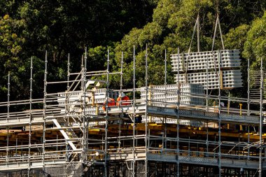 İşçiler, Avustralya 'daki 56-58 Beane St. Gosford' daki yeni sosyal konut bloğunda PVC Wall ile birlikte çalışıp yükleme yapıyorlar. 26 Mart 2021. İnşaat serisinin bir parçası.