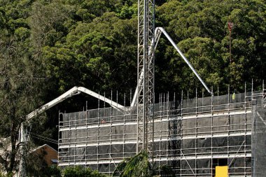 İnşaat devam ediyor. Çalı zemini olan yeni inşaat alanına Beton Patlatma Pompası. 56-58 Beane St. Gosford 'da yeni sosyal konut geliştirme birimi. 30 Mart 2021. Avusturalya.