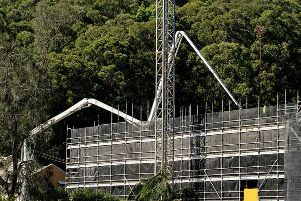 İnşaat devam ediyor. Çalı zemini olan yeni inşaat alanına Beton Patlatma Pompası. 56-58 Beane St. Gosford 'da yeni sosyal konut geliştirme birimi. 30 Mart 2021. Avusturalya.