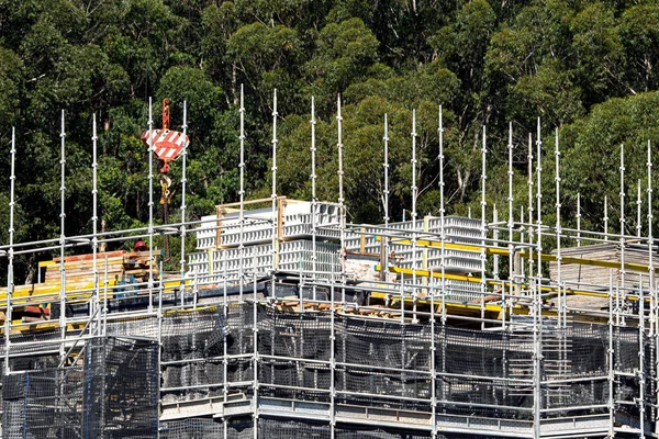 56-58 Beane St. Gosford, Avustralya 'daki yeni sosyal konutların PVC beton duvar formlarını yükleyen işçiler. 10 Nisan 2021. İnşaat serisinin bir parçası.