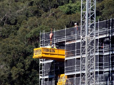 Avustralya, Gosford, 17 Mayıs 2021. İşçiler inşaat serisinin bir parçası olan 56-58 Beane Caddesi 'ndeki yeni sosyal konut inşaatına ekipman boşaltıyor..