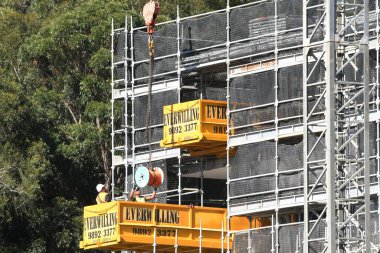 Avustralya, Gosford, 18 Mayıs 2021. İşçiler inşaat serisinin bir parçası olan 56-58 Beane Caddesi 'ndeki yeni sosyal konut inşaatına ekipman boşaltıyor..