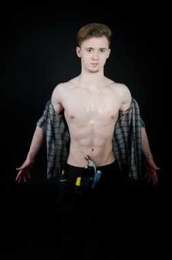 Genç seksi tamirci. Çıplak çocuk. Studio poz. Siyah arka plan.