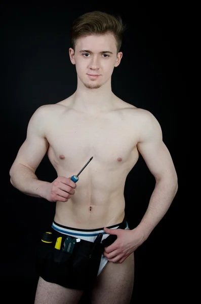 Young sexy handyman. Naked boy. Posing in studio. Black background. — Stock Photo, Image