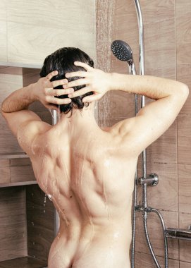 Genç çekici adam duşta yıkanıyor..
