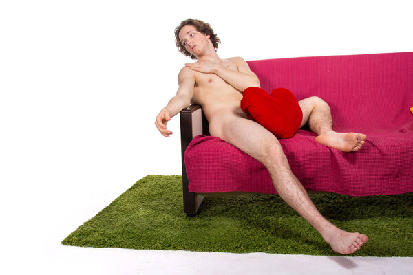 Young attractive guy is resting on the couch. White background. 