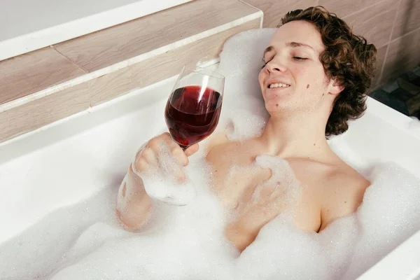 Jovem Cara Atraente Está Descansando Uma Banheira Com Espuma — Fotografia de Stock