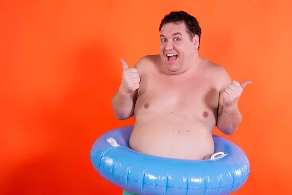 Funny fat guy and vacation. Happy man with an inflatable ring.