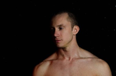 Duşun altında sırılsıklam genç yakışıklı bir adam..