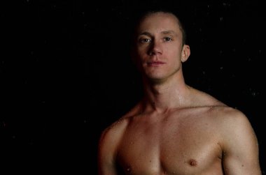 Duşun altında sırılsıklam genç yakışıklı bir adam..