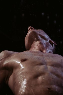 Duşun altında sırılsıklam genç yakışıklı bir adam..