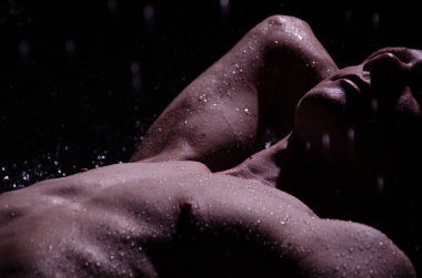 Duşun altında sırılsıklam genç yakışıklı bir adam..