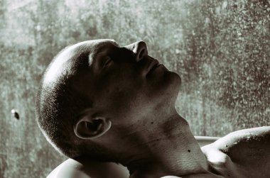 Duşun altında sırılsıklam genç yakışıklı bir adam..