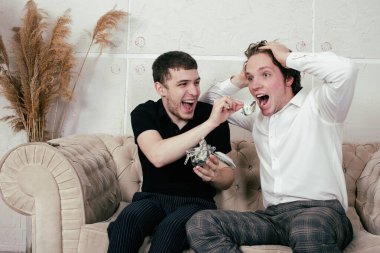 Genç mutlu eşcinsel çift evde dinleniyor ve haberleri seyrediyor..