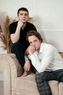 Genç mutlu eşcinsel çift evde dinleniyor ve haberleri seyrediyor..