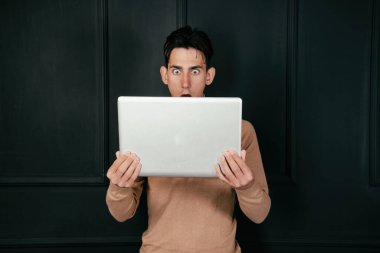 Bilgisayarı ve telefonu olan mutlu genç bir öğrenci..