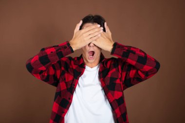 Noel ve Yeni Yıl. Genç ve komik bir adam tatilin tadını çıkarıyor. Kahverengi arkaplan.