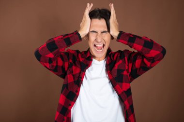 Noel ve Yeni Yıl. Genç ve komik bir adam tatilin tadını çıkarıyor. Kahverengi arkaplan.