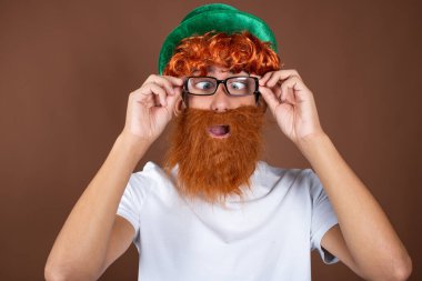 Aziz Patrick Günü 'nde. Kahverengi arka planda kızıl sakallı komik bir adam..