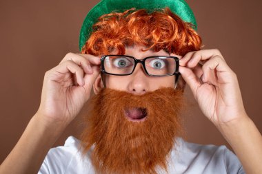 Aziz Patrick Günü 'nde. Kahverengi arka planda kızıl sakallı komik bir adam..