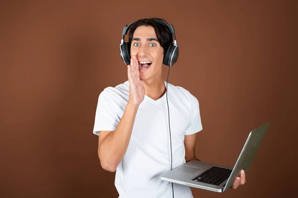 Handsome guy listens to music with headphones.