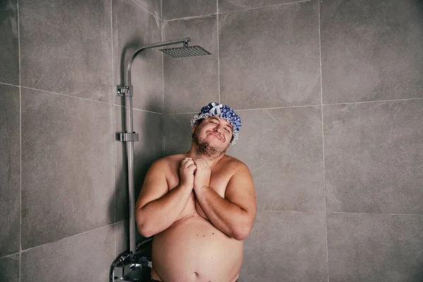 Funny fat man washes in the shower.