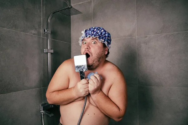 Funny fat man washes in the shower.