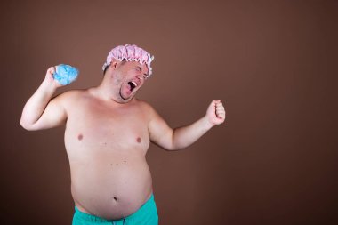 Duştaki komik şişman adam. Kahverengi arkaplan.