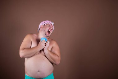 Duştaki komik şişman adam. Kahverengi arkaplan.