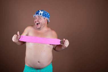 Duştaki komik şişman adam. Kahverengi arkaplan.