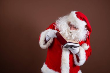 Komik Noel Baba kitap okur. Kahverengi arkaplan.