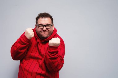 Komik şişman adam. Çalış ve çalış. Kırmızı kazak..