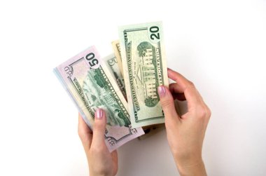 Kadın eli para sayar. Kadınlar bir tomar doları elle sayar.