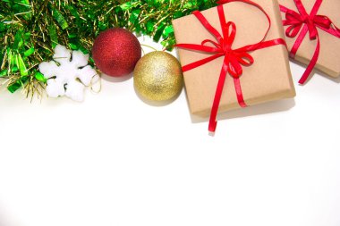 Kırmızı kurdeleli hediye kutuları ve Noel süsleri beyaz arka plana yerleştirilir..