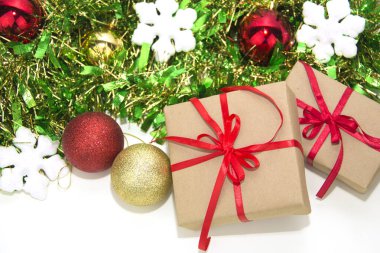 Kırmızı kurdeleli hediye kutuları ve Noel süsleri beyaz arka plana yerleştirilir..