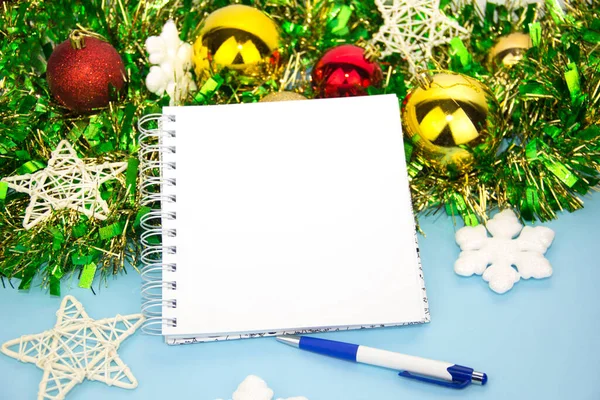 Notepad for notes with a pen and Christmas decorations. New years blue background. Space for text. Background of the new year. Christmas. Noel. Clean open Notepad, Christmas gifts Stock Photo