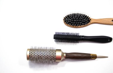 Beyaz arka planda profesyonel taraklar. Hafif bir arka planda üç tarak. Metin için boşluk.