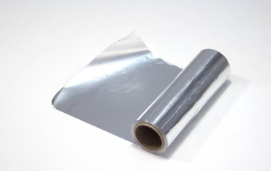 Beyaz arka planda bir rulo alüminyum folyo. Kuaför için folyo
