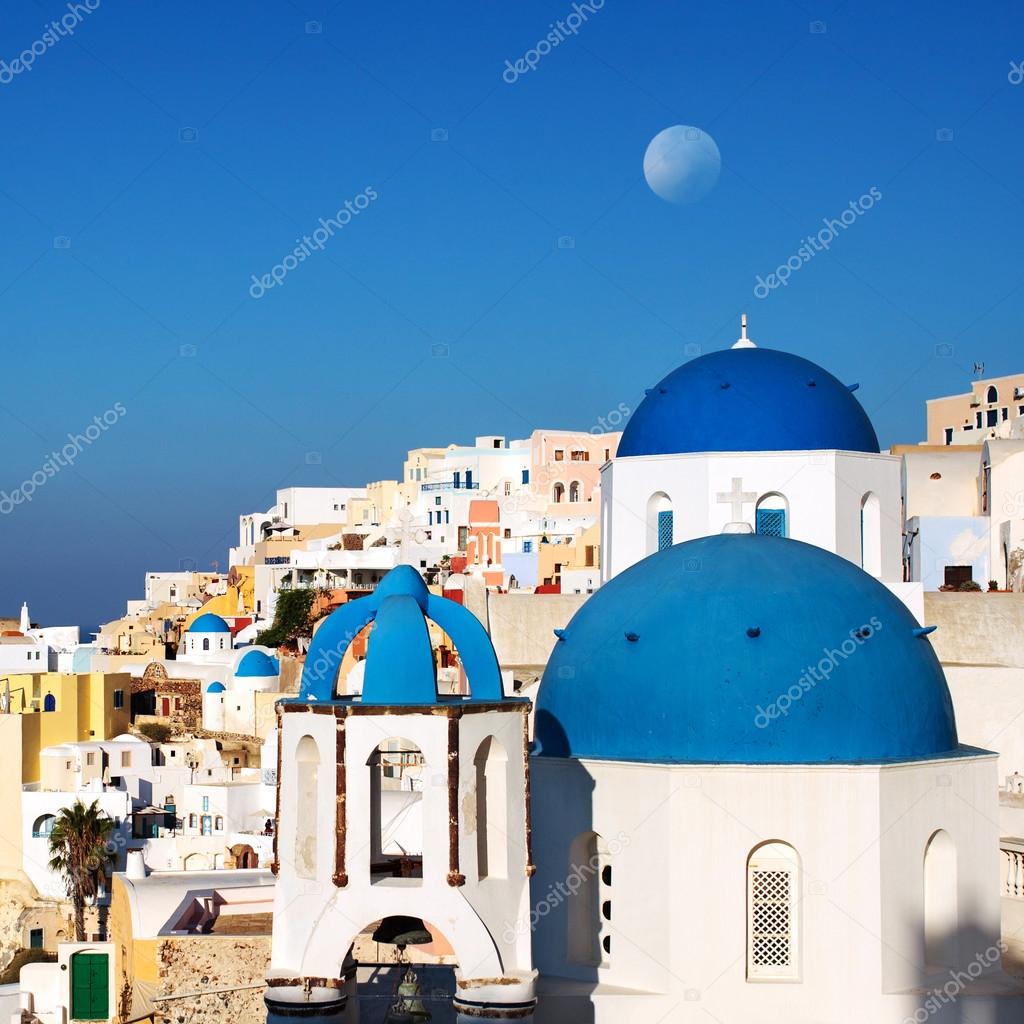 Santorini blue dome churches with moon. Oia Village, Greece.