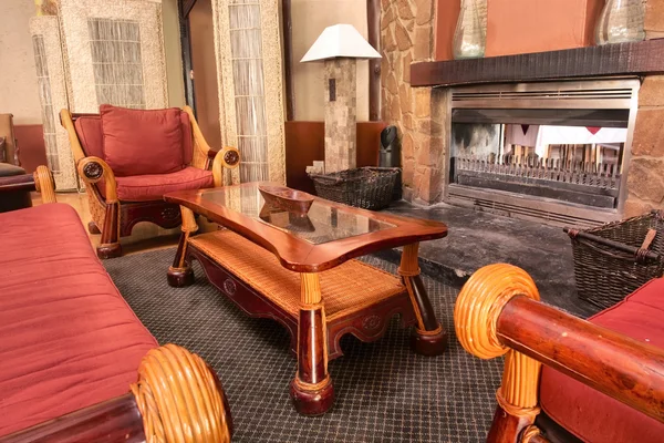 Habitación rústica con muebles rojos y chimenea — Foto de Stock