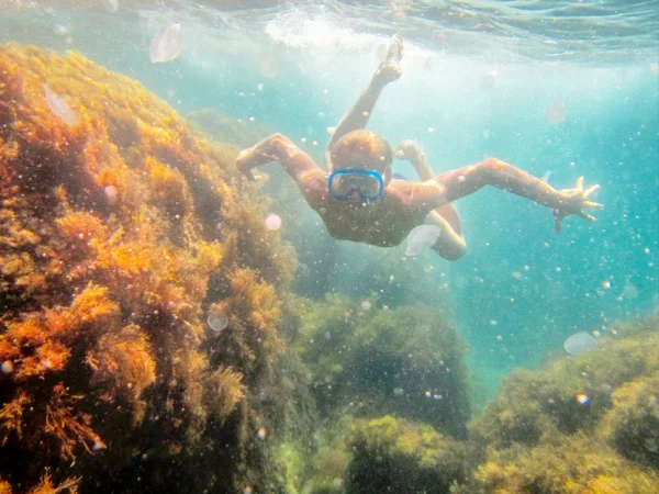 Teenage boy swims under water in sea — Stock Photo, Image