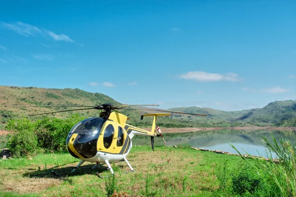 Helicóptero amarelo na ilha do lago Fotografias De Stock Royalty-Free