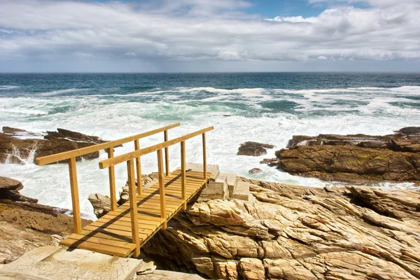 Spiaggia rocciosa e ponte di legno — Foto Stock