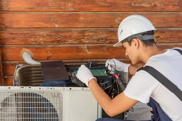 Een Jonge Elektricien Repareert Een Airco Splitsing Systeemonderhoud — Stockfoto