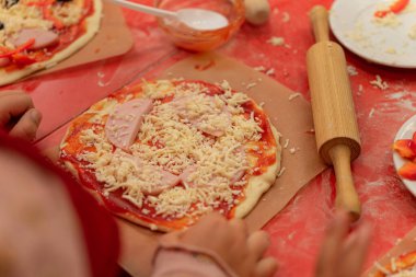 Çocuk pizzası ustası, bebek eli pizza yapıyor.