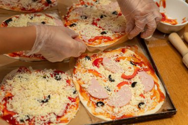 Pizza pişirme dersi. Pizzayı şeflerin elleri yapar.