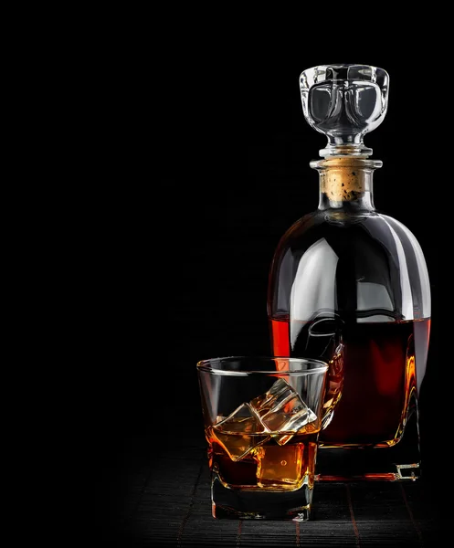 工作室拍摄的威士忌在玻璃水瓶和玻璃上黑色孤立 — 图库照片