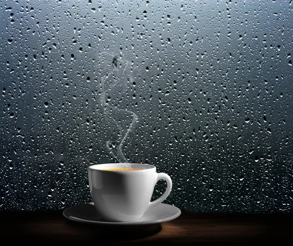 Parze filiżankę kawy na tle okna deszczowy dzień — Zdjęcie stockowe