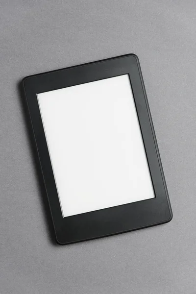 Electronic reader with blank screen on a grey background. Concepts of technology and modernity. Image with copy space.