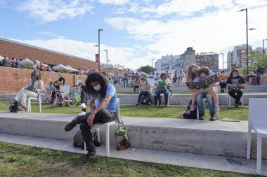 Buenos Aires, Arjantin; 2 Nisan 2021: Felba, Yayıncılar ve Kitapçılar Fuarı sırasında maske takan ve mesafeyi koruyan farklı yaşlardaki insanlar okuma etkinliğinde